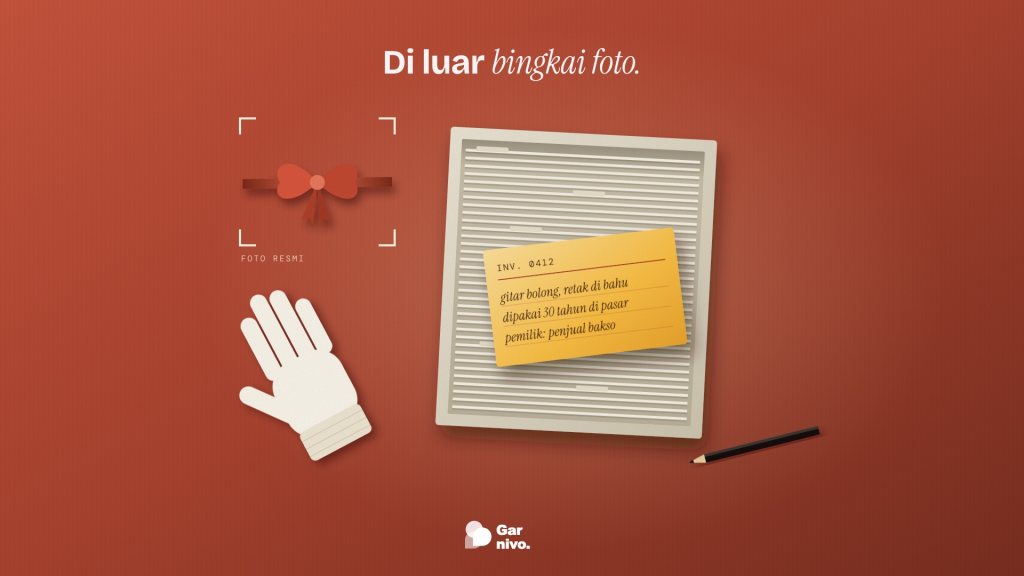 Tampak atas meja terakota: pita seremoni kecil di dalam bingkai foto, sementara kotak arsip, kartu inventaris amber, dan sarung tangan katun di luarnya.
