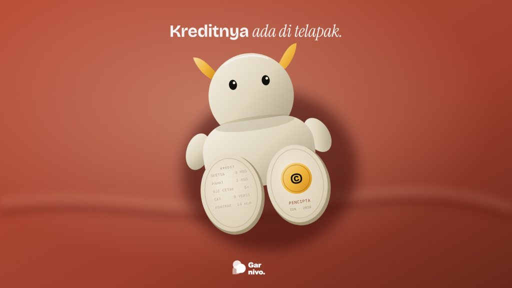 Figur vinil krem bertanduk amber duduk memperlihatkan dua telapak kaki: satu berisi daftar kredit kerja timbul, satu berlencana amber pencipta, di kain terakota.